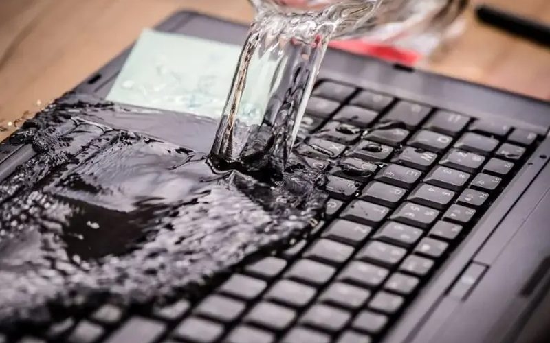 Woda wylewana na klawiaturę laptopa — ilustracja zalania